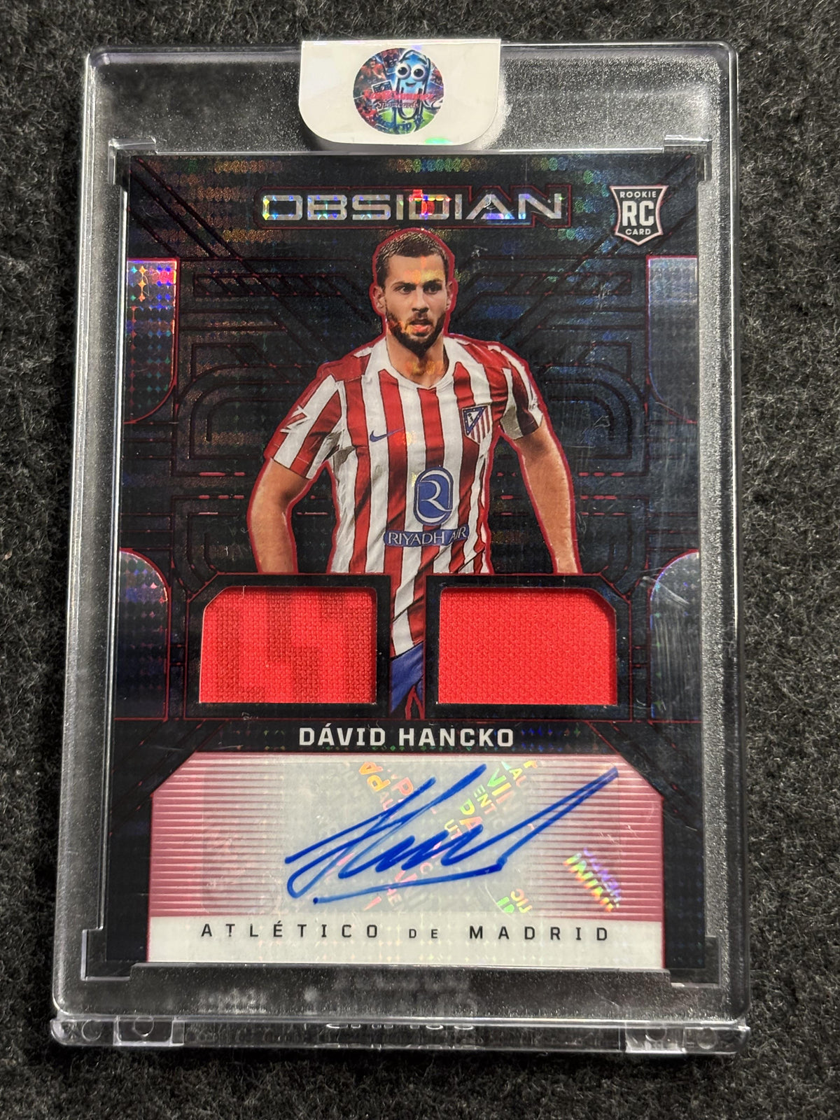 2025-26 Panini Obsidian #DJ-DHO David Hancko Dual Jersey Ink – Electric Etch Red Pulsar /48 Atletico Madrid SN, RC, AU